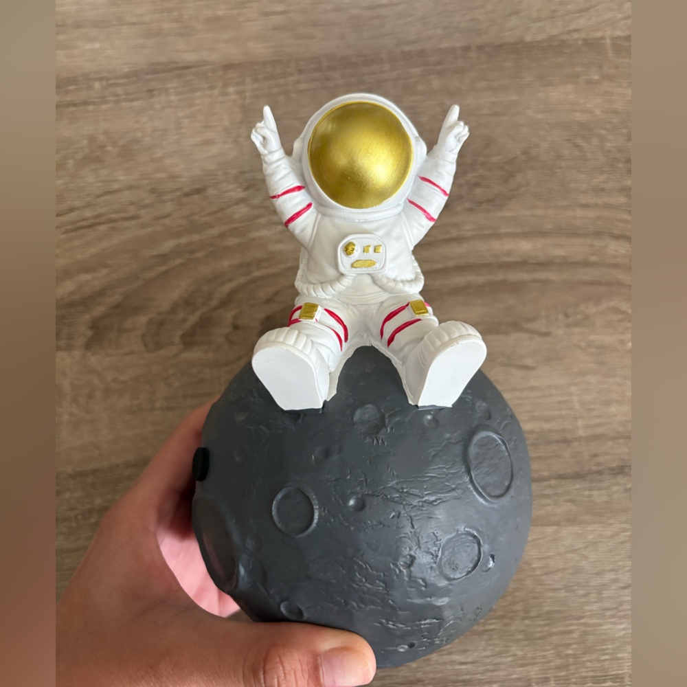 Astronaut sitting on the Moon Piggybank